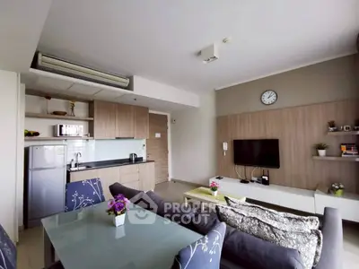 Modern living room with open kitchen, stylish decor, and cozy seating area.