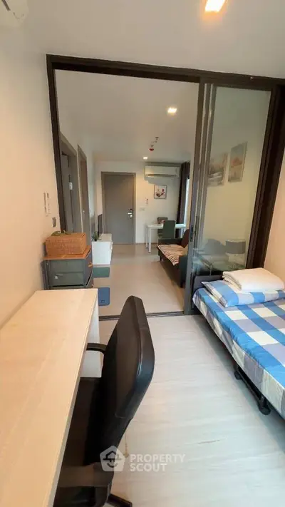 Modern studio apartment with sleek design and functional layout, featuring a cozy bed and workspace.
