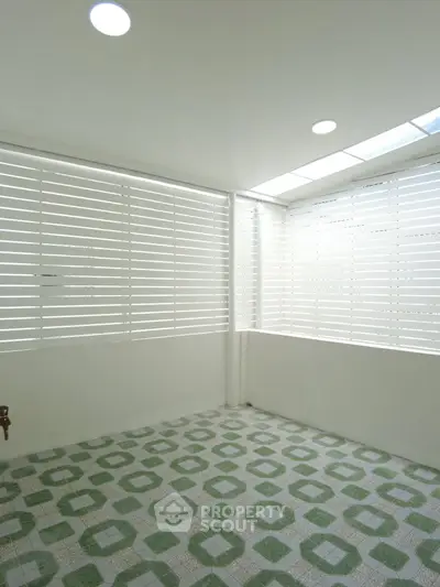 Bright enclosed balcony with patterned tile flooring and modern design.