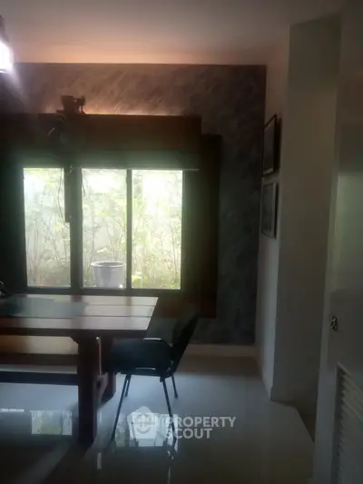 Cozy dining area with natural light and garden view, perfect for intimate gatherings.