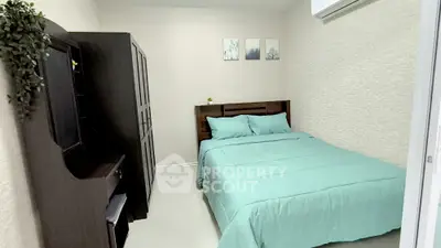 Cozy bedroom with modern furniture and soft teal bedding in a stylish apartment.