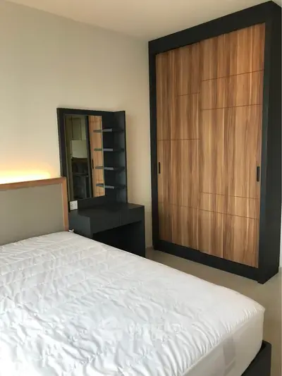 Modern bedroom with sleek wardrobe and stylish vanity in a contemporary apartment.