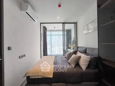 Modern bedroom with stylish decor and large window offering natural light