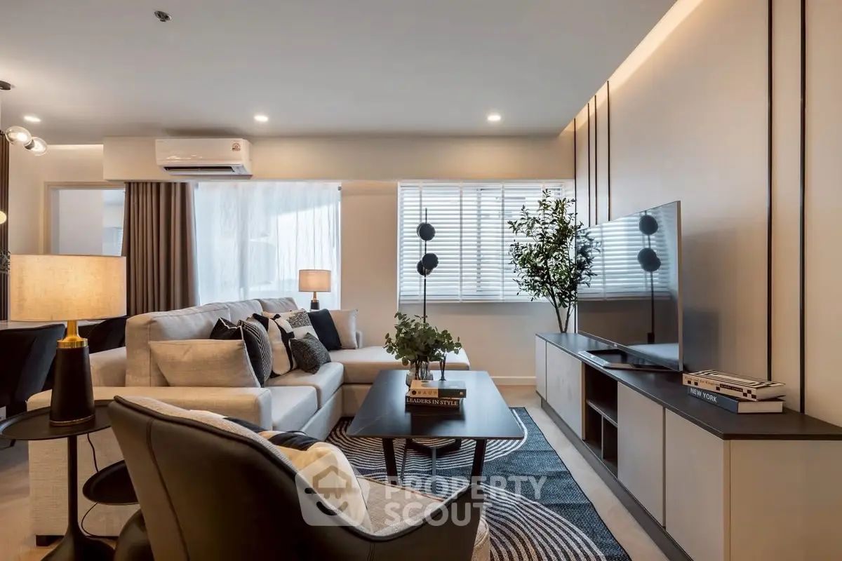 Modern living room with stylish decor, large TV, and cozy seating area.
