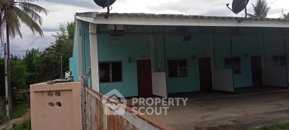 Charming blue exterior building with multiple units and lush greenery.