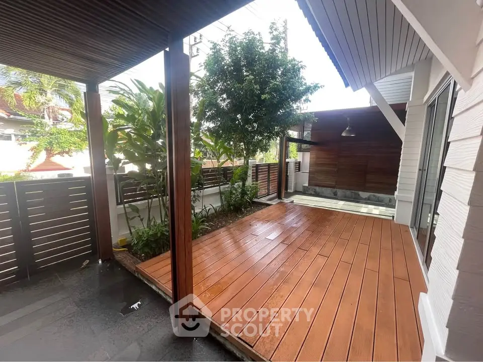 Charming wooden deck patio with lush greenery and modern design, perfect for outdoor relaxation.