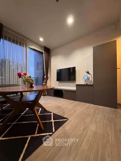 Modern living room with stylish decor and large window offering natural light.