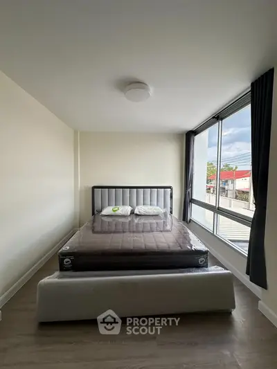 Modern bedroom with large window and stylish bed in a bright apartment