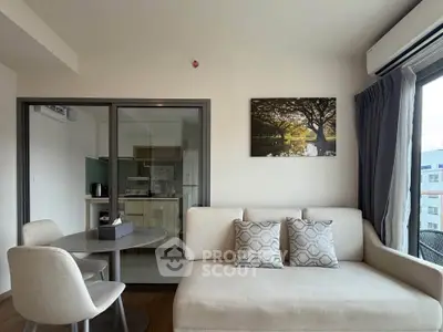 Modern living room with stylish decor and kitchen view in a cozy apartment.