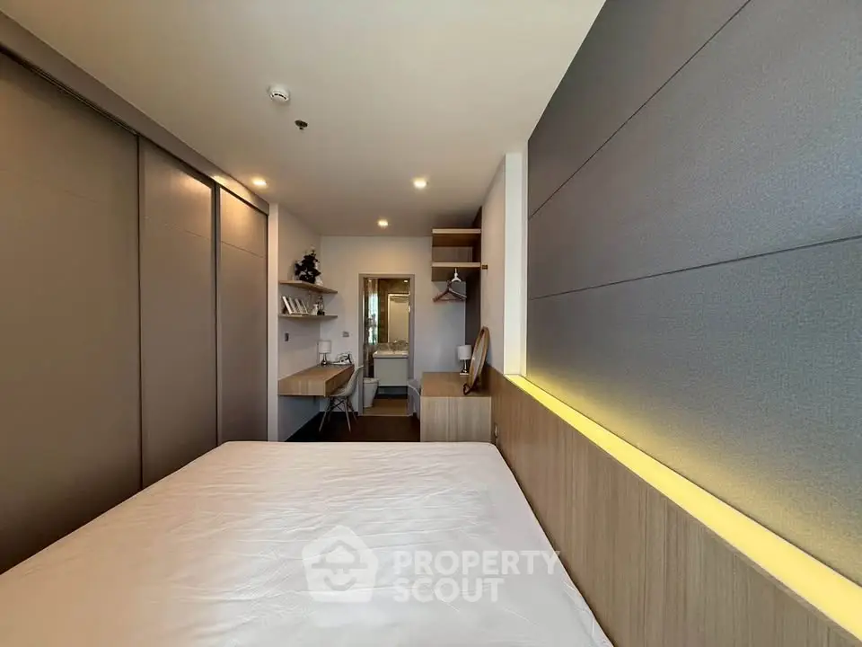 Modern bedroom with sleek design and integrated workspace, featuring ambient lighting and ample storage.