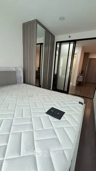 Modern bedroom with sleek design and mirrored wardrobe in a stylish apartment.