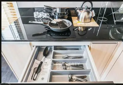 Modern kitchen with sleek black countertop and organized cutlery drawer