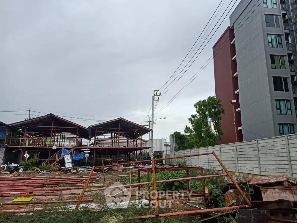 Vacant land with construction materials beside modern apartment building