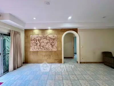 Spacious living room with decorative wall art and tiled flooring