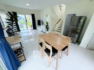Modern open-plan living room with dining area and sleek kitchen appliances