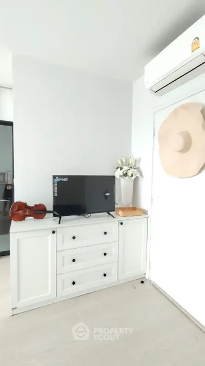 Chic modern living room with stylish white cabinet and wall-mounted air conditioner