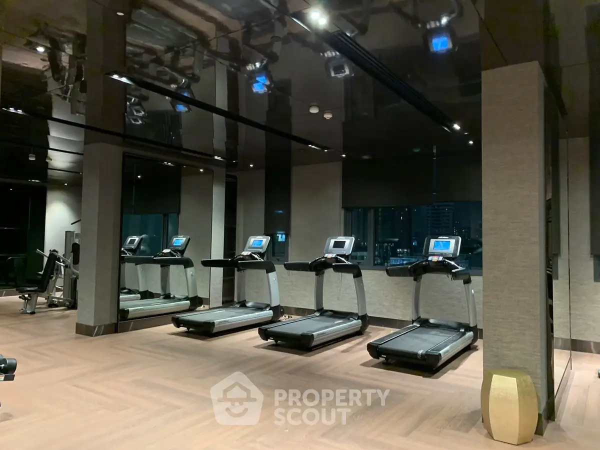 Luxurious gym with modern treadmills and sleek design in upscale residential building.