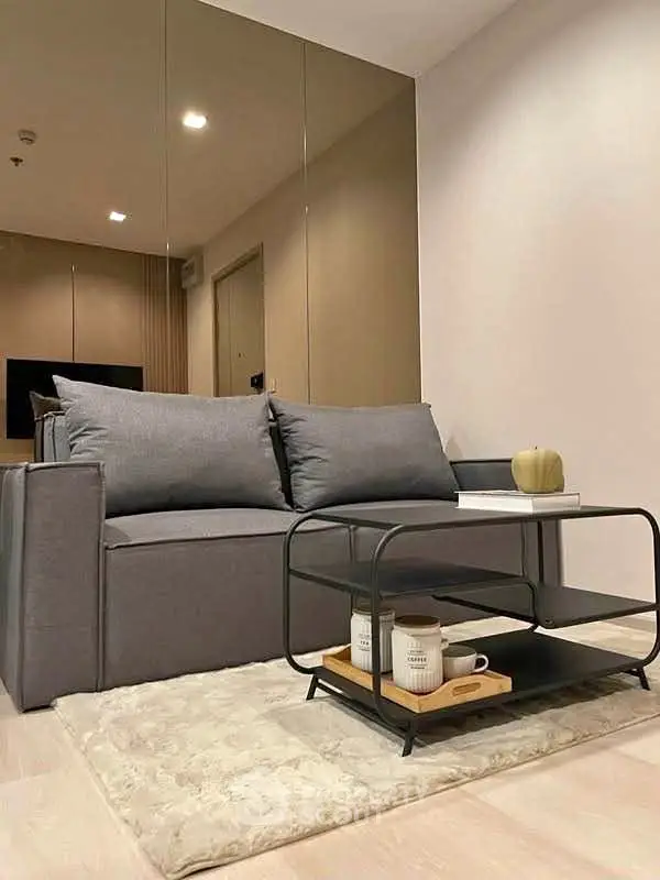 Modern living room with stylish gray sofa and sleek coffee table on a plush rug.