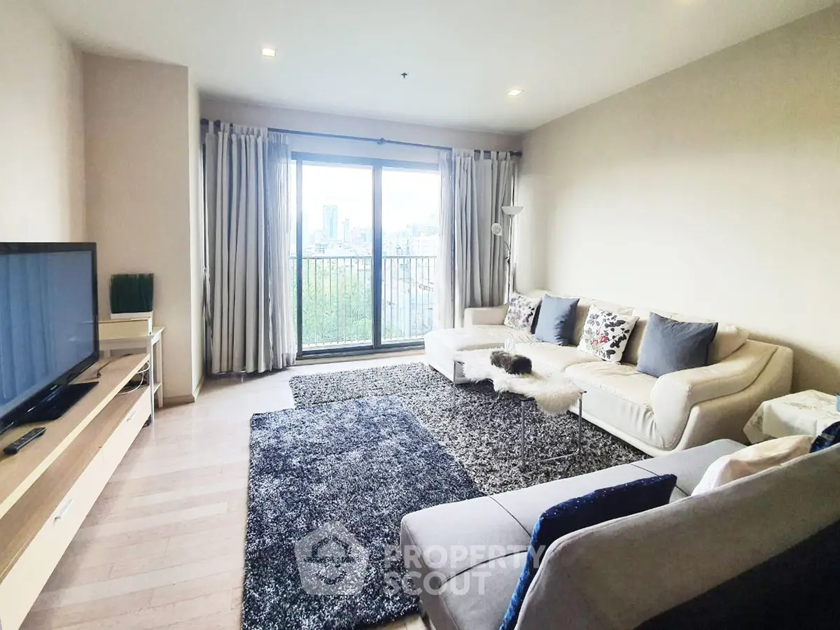 Spacious living room with modern decor and city view, featuring cozy sofas and a large TV.