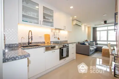 Modern open-layout kitchen and living room with sleek design and ample natural light.