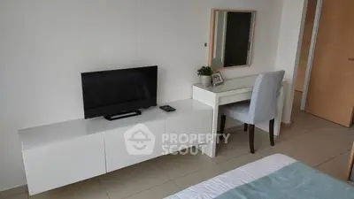 Modern bedroom with sleek TV setup and stylish vanity desk