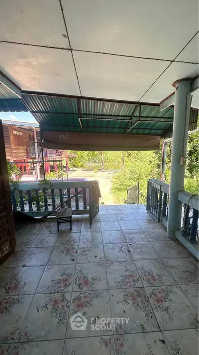 Charming rustic porch with floral tiles and lush greenery view