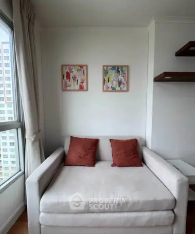 Cozy living room corner with a plush armchair and modern wall art, perfect for relaxation.