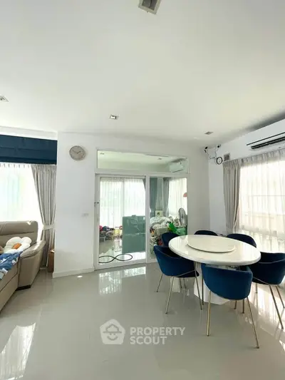 Bright and spacious living room with modern dining area and elegant decor.