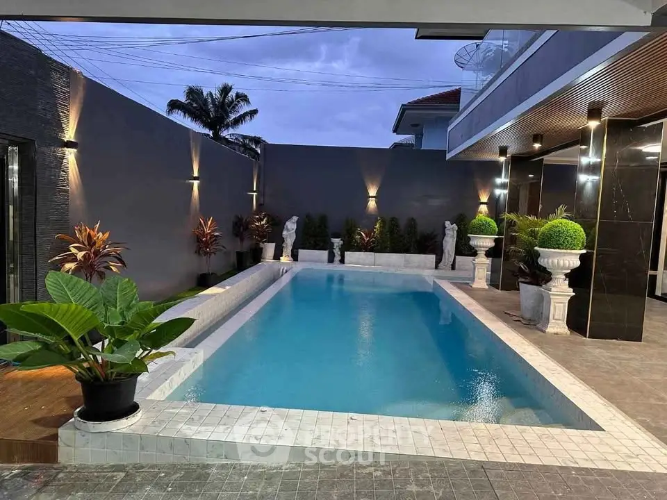 Luxurious modern pool area with elegant lighting and lush greenery, perfect for relaxation and entertainment.