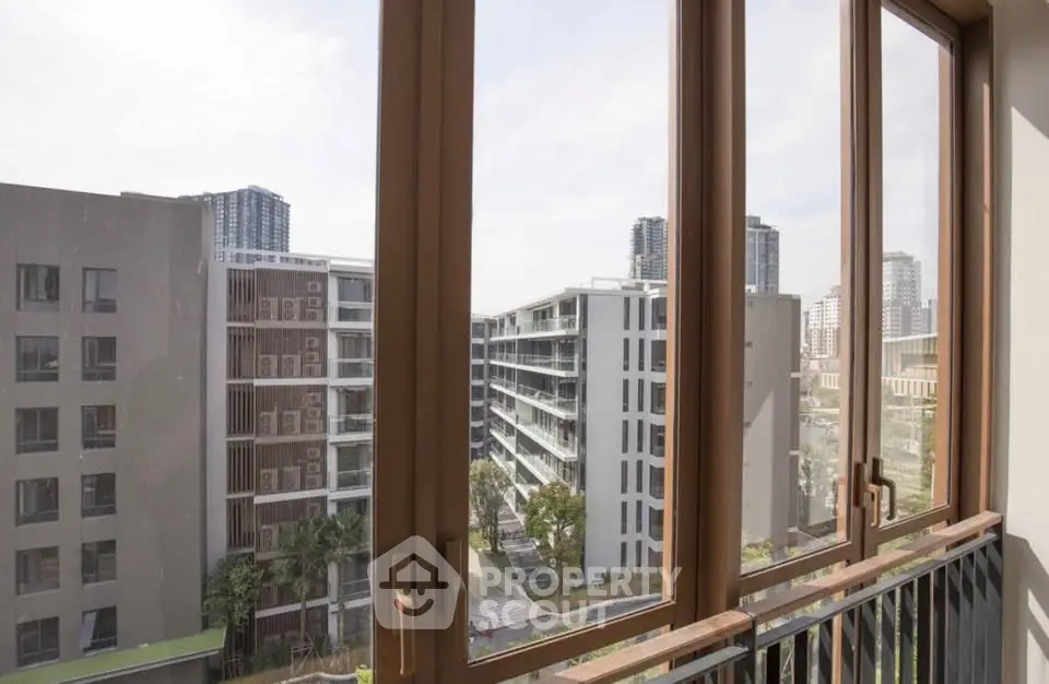 Stunning urban view from a modern apartment window showcasing city skyline and contemporary architecture.