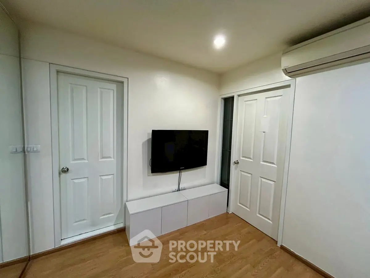 Modern living room with wall-mounted TV and sleek storage unit