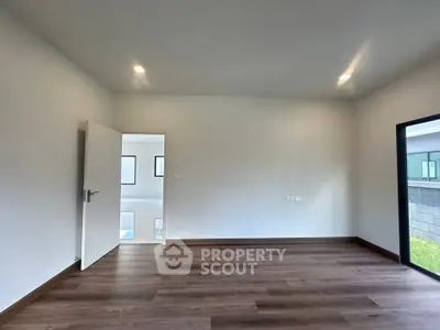Spacious modern room with wooden flooring and ample natural light