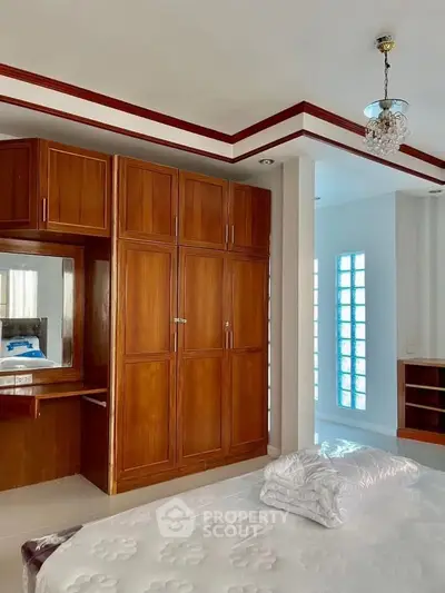 Spacious bedroom with elegant wooden wardrobe and modern lighting