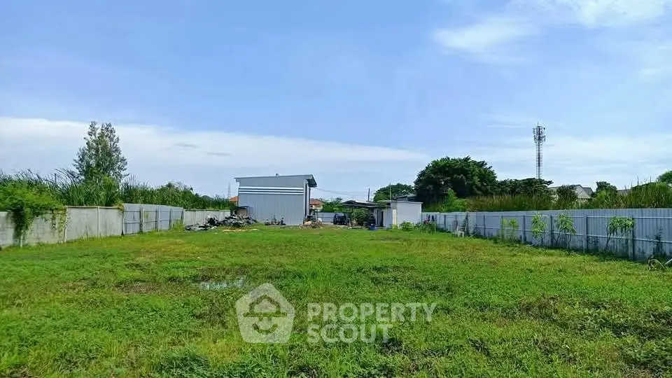 Spacious green land plot with a small building, perfect for development opportunities.
