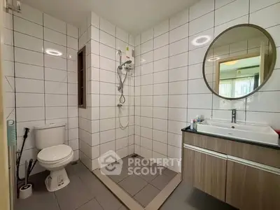 Modern bathroom with sleek tiles and round mirror