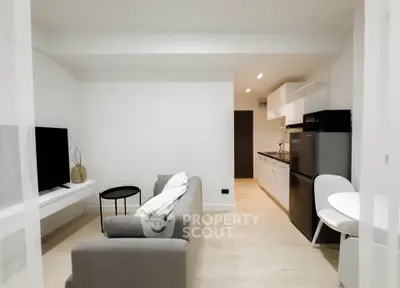 Modern living room with open kitchen, sleek design and neutral tones