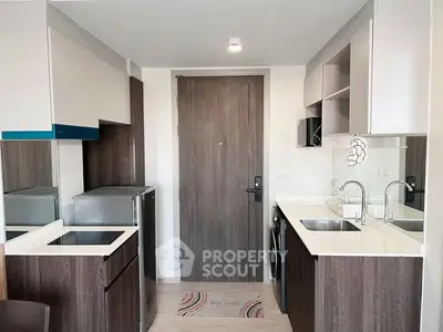 Modern compact kitchen with sleek cabinetry and integrated appliances in a stylish apartment.