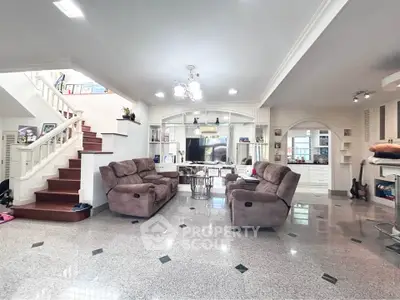 Spacious living room with elegant staircase and cozy seating area