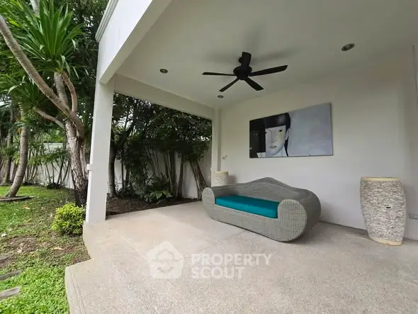 Charming outdoor patio with modern seating and lush garden view.