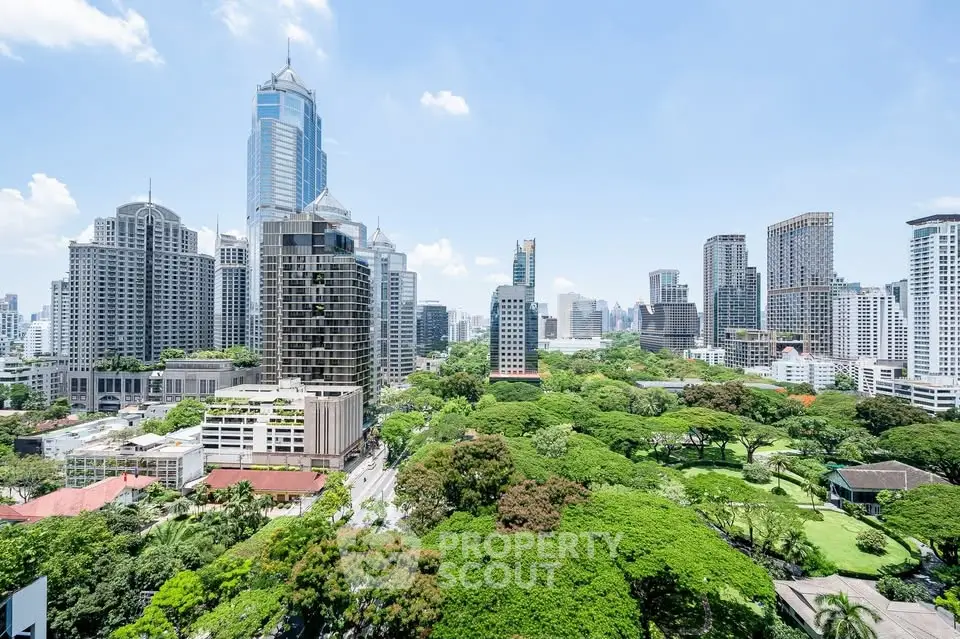 Stunning cityscape view with lush greenery and modern skyscrapers under a clear blue sky.