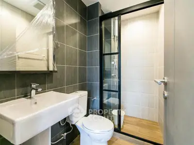 Modern bathroom with sleek design, featuring a glass shower enclosure and stylish fixtures.