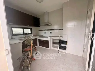 Modern kitchen with sleek cabinetry and tiled backsplash, featuring a bicycle for unique decor.