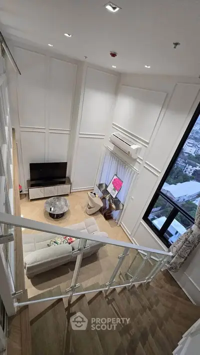 Luxurious high-ceiling living room with modern decor and large window view.
