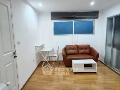 Modern living room with cozy brown sofa, sleek white table, and stylish chair, perfect for urban living.