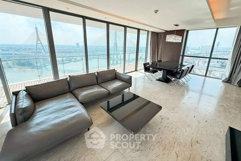Luxurious living room with stunning river view and modern furnishings in high-rise apartment.