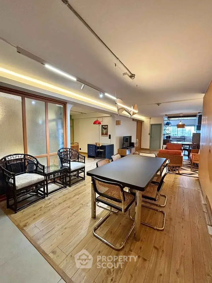 Spacious living room with modern dining area and stylish seating, perfect for entertaining guests.