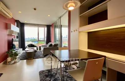 Modern living room with city view, featuring stylish furniture and natural light.