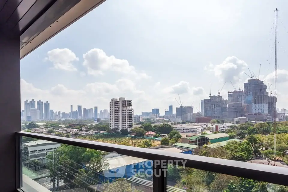 Stunning cityscape view from a modern balcony, showcasing urban skyline and lush greenery.