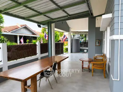 Charming covered patio with wooden furniture and garden view in a suburban home