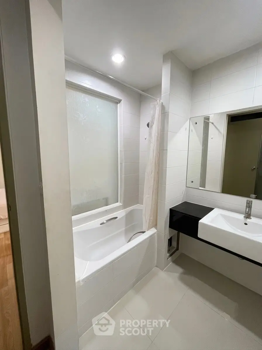 Modern bathroom with sleek design featuring a bathtub and stylish sink area.